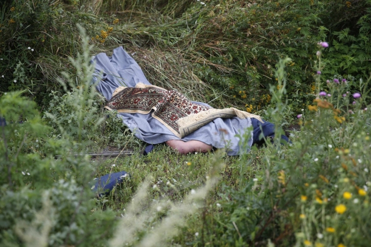 A rug covers the body of a passenger of a Malaysian Airlines Boeing 777 plane which was downed on Thursday near the village of Rozsypne